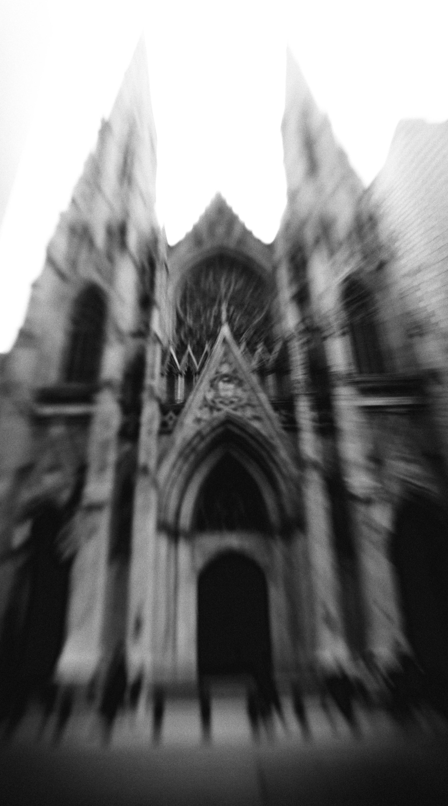 Gothic cathedral facade with dramatic zoom blur effect creating radial motion lines from the ornate arched entrance