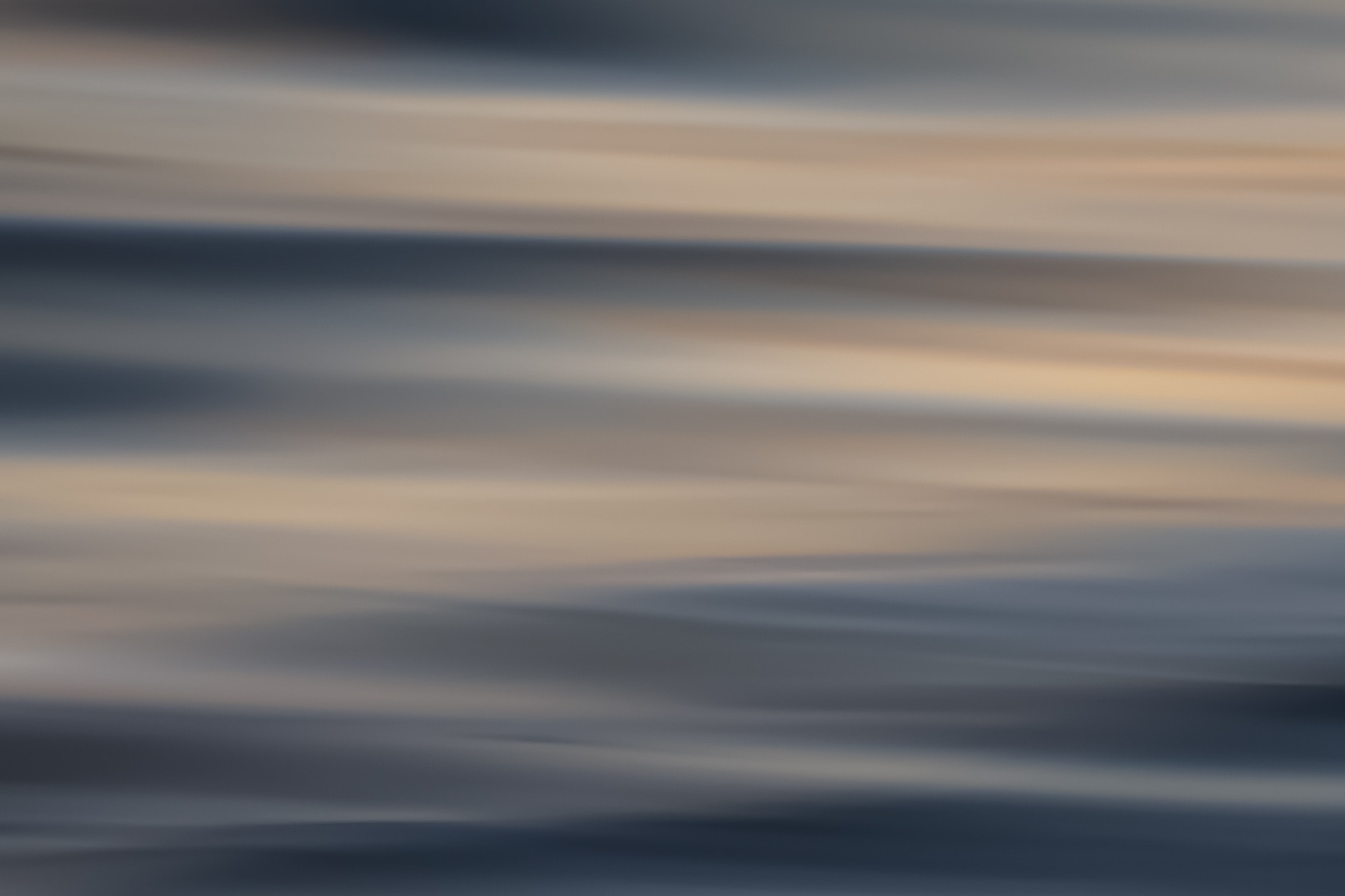 Soft abstract ocean motion blur with warm peach and cool blue horizontal bands