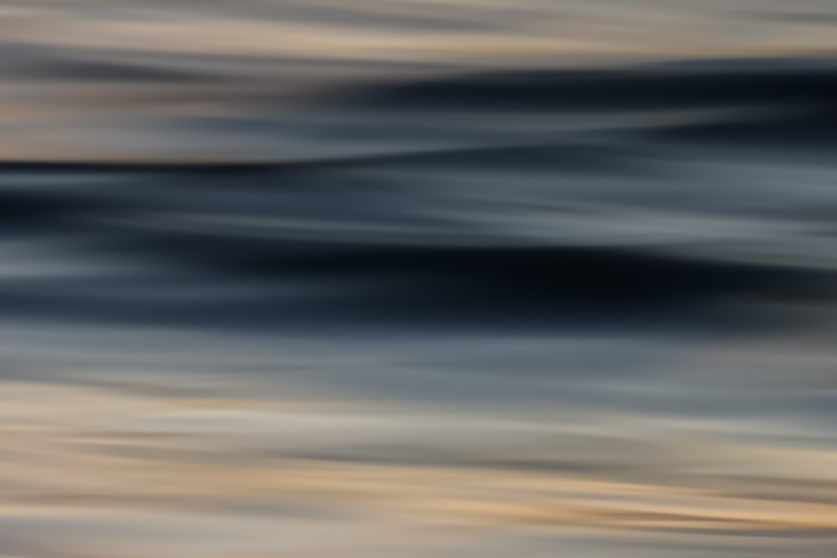 Abstract seascape motion blur with deep dark wave crest and warm golden lower tones