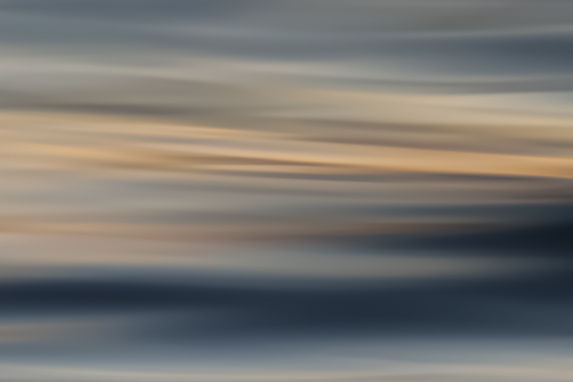 Abstract ocean motion blur with bold diagonal golden light rays over dark blue water