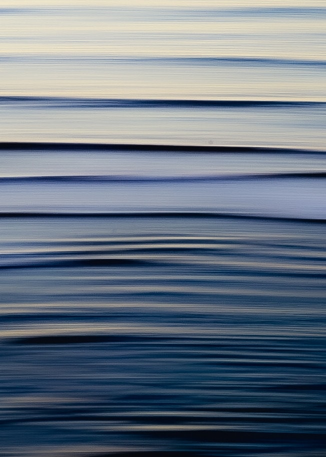 Abstract motion blur ocean surface with stacked horizontal striations of cream, periwinkle and deep navy