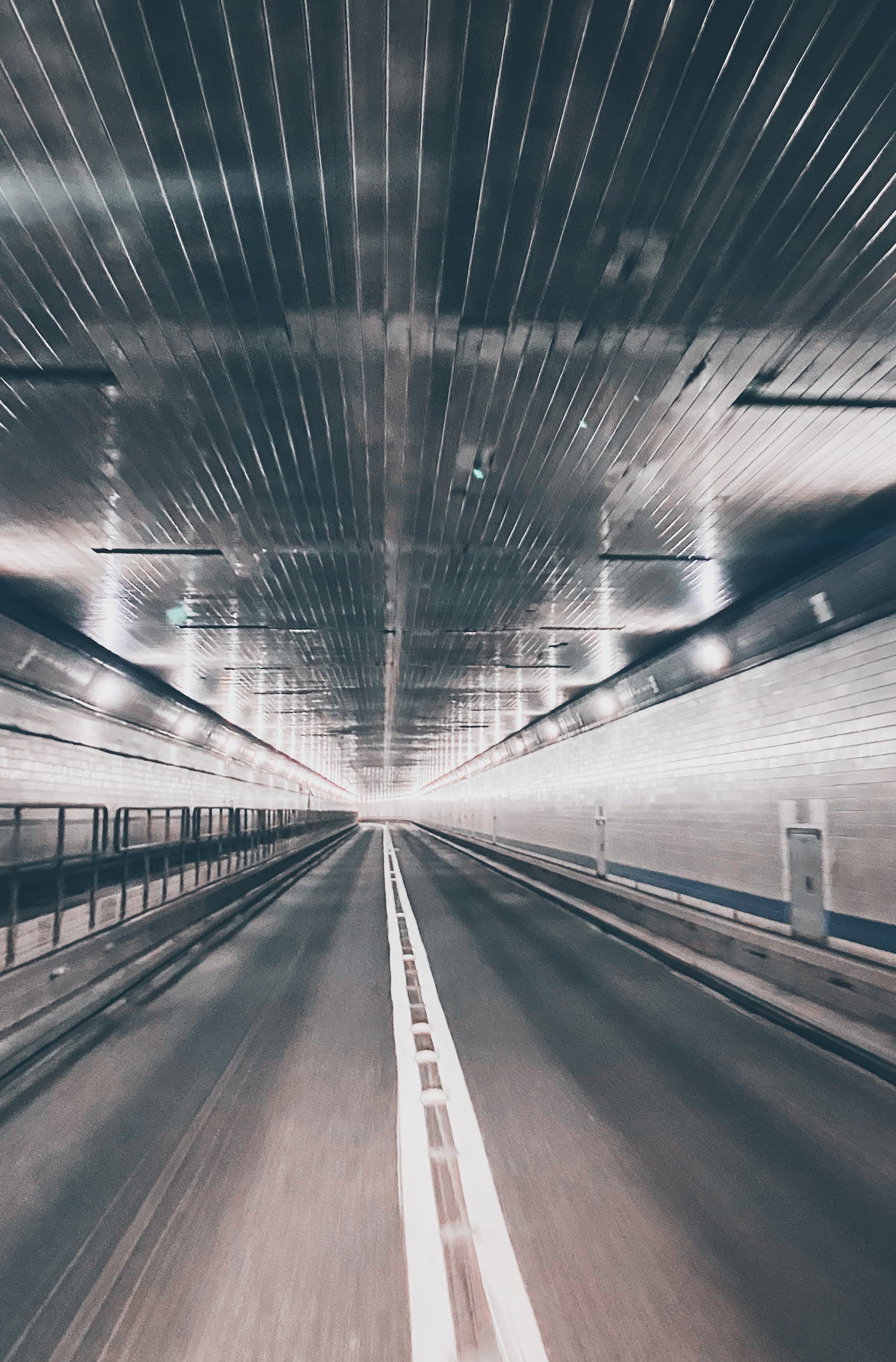 Motion blur inside illuminated highway tunnel with strong vanishing point perspective