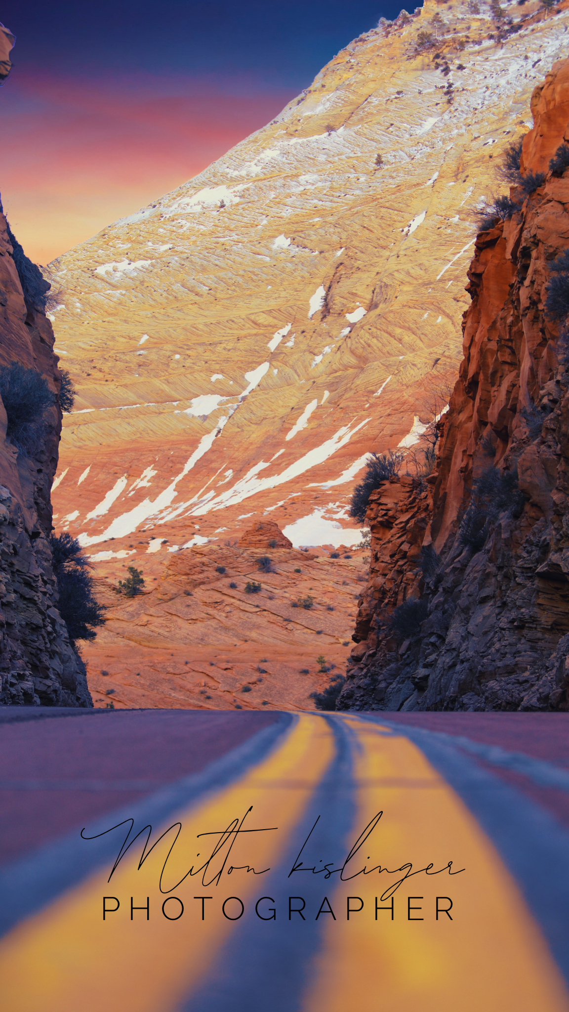 Desert canyon road with dramatic red rock walls and snow-dusted cliffs at dusk